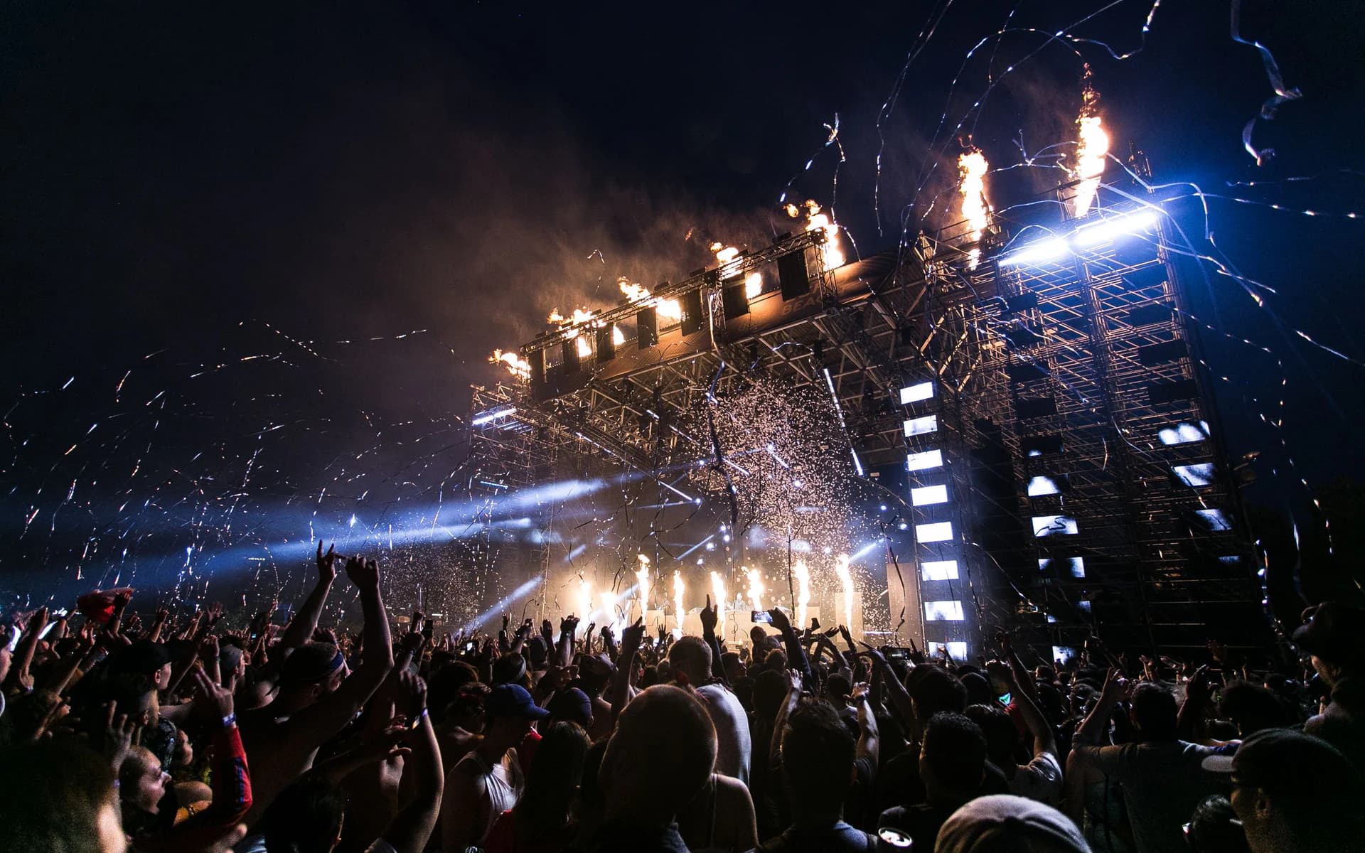 A crowd facing an electronic music festival stage